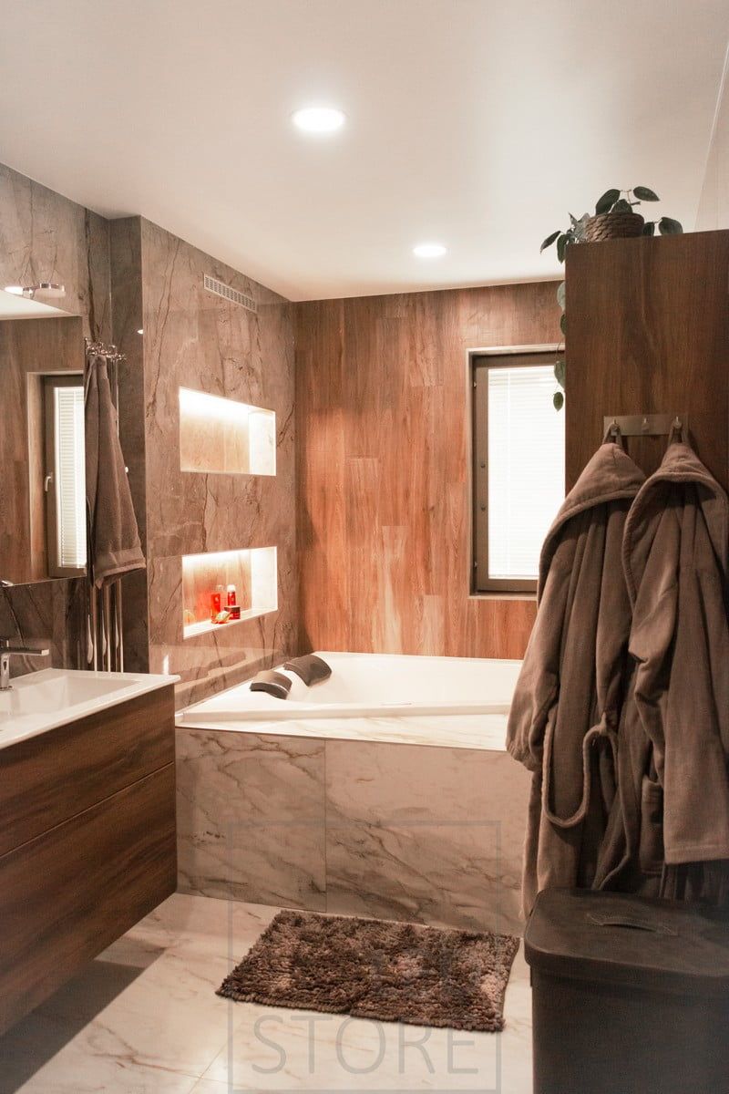 Bathroom with LED ceiling tiles in the ceiling. The light provided by the luminaire is more uniform than a spotlight and is ideal for general lighting. LED strip lights on the shampoo shelves provide additional atmospheric light. Ledstore.fi
